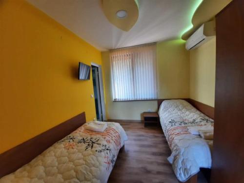 丘斯滕迪尔Райчевата къща - Кюстендил的黄色墙壁客房的两张床