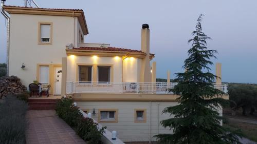 亚历山德鲁波利斯Magnificent View Villa的一座带门廊和圣诞树的大型白色房屋