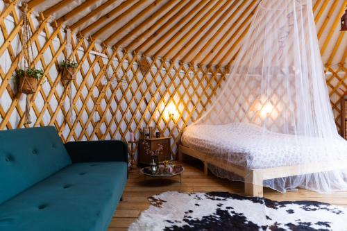 巴克瑟姆YURs的蒙古包内带一张床和一张沙发的房间