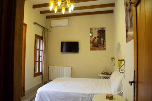 突尼斯Dar El Halfaouine的卧室配有白色的床和电视