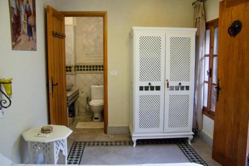 突尼斯Dar El Halfaouine的一间带卫生间和白色门的浴室