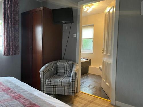 巴洛赫格万里亚宾馆的一间卧室配有椅子和电视