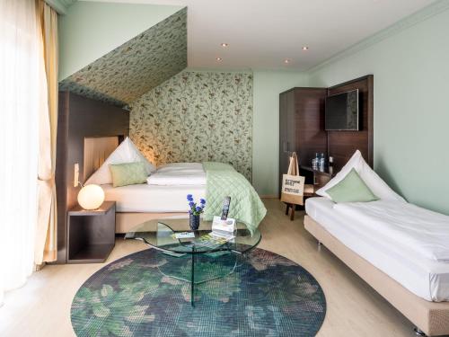 勒沃库森Kristallhotel Fettehenne的一间卧室配有两张床和一张玻璃桌