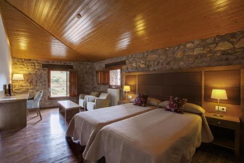 Montenegro de CamerosPosada Real La Almazuela的一间卧室设有一张大床和石墙