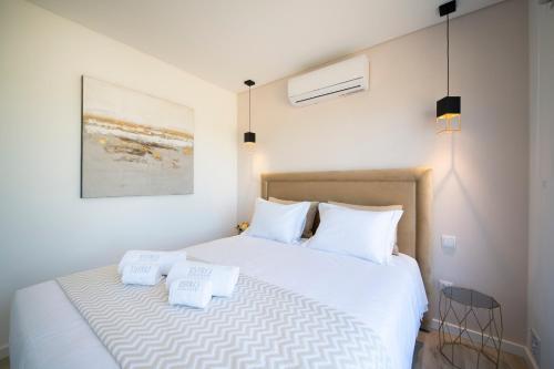格兰杜拉Monte Lusitano Calmaria的卧室配有白色床和2个白色枕头