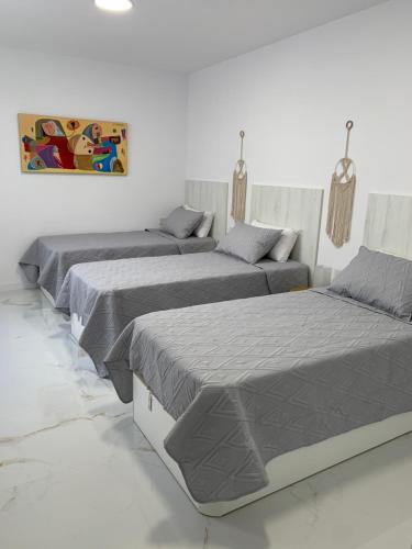 大加那利岛拉斯帕尔马斯Apartamento Casa Blanca的白色客房内的三张床,