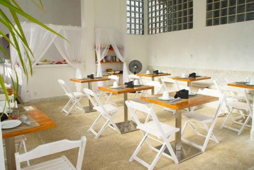 莫罗圣保罗Villa Amado的配有木桌和白色椅子的房间