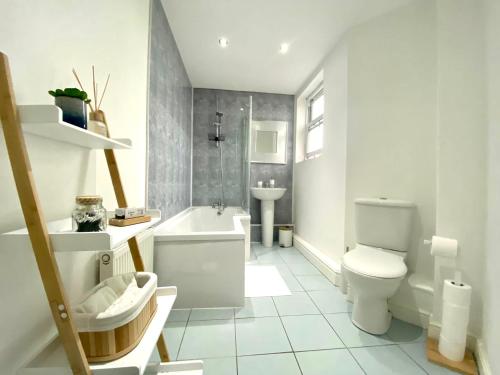 利物浦LOVELY STYLISH APARTMENT NEAR PENNY LANE! FREE PARKING的白色的浴室设有卫生间和水槽。