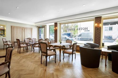 慕尼黑卡拉夫特酒店的一间带桌椅的用餐室和窗户。