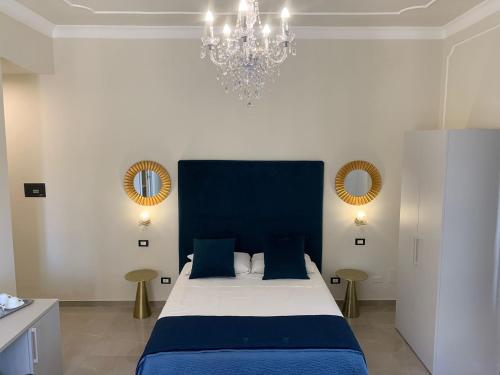 巴勒莫Amaris的一间卧室配有蓝色的床和吊灯。