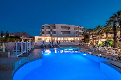 古瓦伊Gouves Bay by Omilos Hotels的夜间在酒店前的游泳池