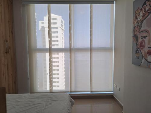 圣玛尔塔Apartamento frente al mar Rodadero Santa Marta的一间卧室设有窗户,享有建筑的景色