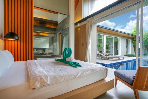 拉扬海滩度Sunpao Pool Villa by HCR的卧室,床上有仙人掌,毗邻游泳池