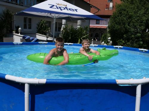 阿特尔高地区圣格奥尔根兰德卡斯托弗斯普利特威尔特酒店的两个男孩在充气游泳池里