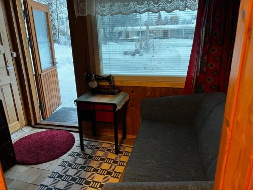 基蒂莱Adorable 1-bedroom cottage/guesthouse in Kittilä的带沙发和窗户的客厅