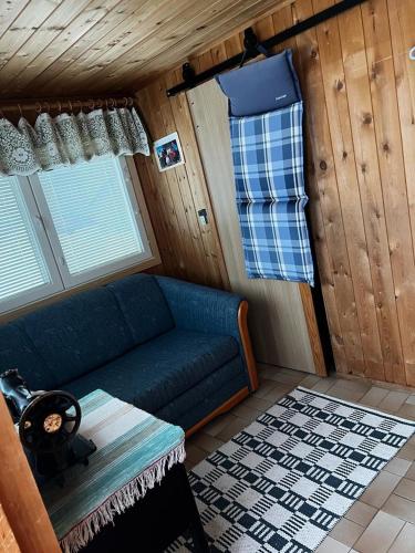 基蒂莱Adorable 1-bedroom cottage/guesthouse in Kittilä的小屋内带蓝色沙发的客厅