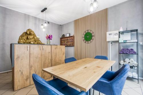 华沙Stara Praga- Dawniej Hostel Krokodyl的一间带木桌和蓝色椅子的用餐室