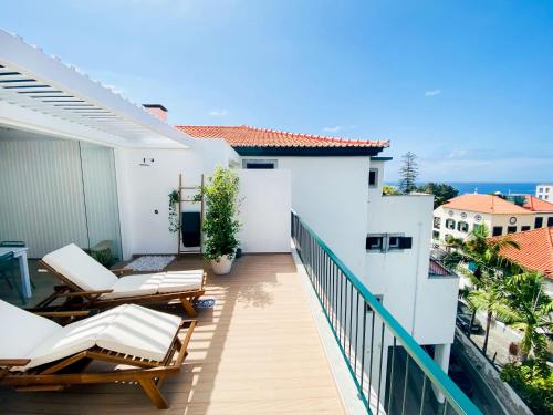 丰沙尔Madeira Precious Penthouse的阳台配有椅子,享有海景。