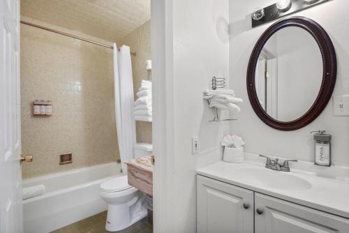 国王海滩Crown Motel的一间带水槽、卫生间和镜子的浴室