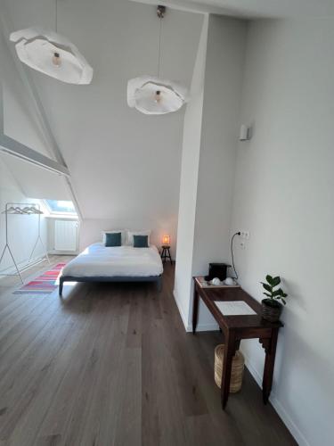 蒂伦豪特Maison Georges的一间卧室配有一张床,铺有木地板