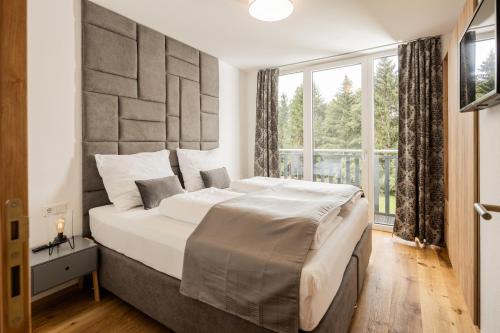 毛特恩多夫Granit Appartements的一间卧室设有一张大床和大窗户
