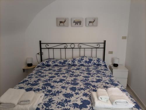 百瑞思西亚诺La Cameretta的卧室配有蓝色和白色的床,提供毛巾