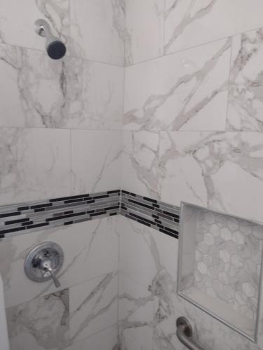 阿普瓦里Sky Fresh Home Stay的一间设有白色大理石墙壁和淋浴的浴室