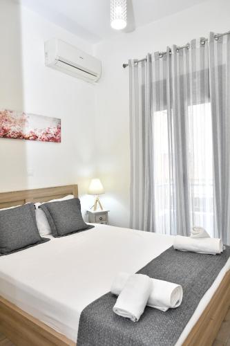 纳夫普利翁Michaela's guesthouse的卧室配有白色的床和2条毛巾