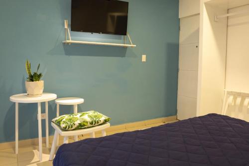 拉利伯塔德阿塔米度假村的卧室配有一张床,墙上配有电视。