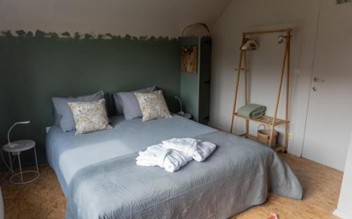 RixensartVilla Plagniau的一间卧室配有一张大床和毛巾