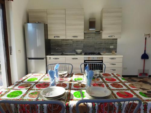 维韦罗内Appartamento doppi bagni sei posti letto的厨房配有桌椅和冰箱。
