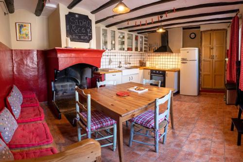 SecastillaSidroAndCo Rural Home的厨房配有木桌和壁炉。