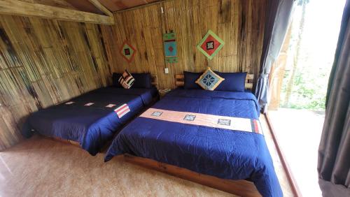 河江Toong homestay的小木屋内一间卧室,配有两张床