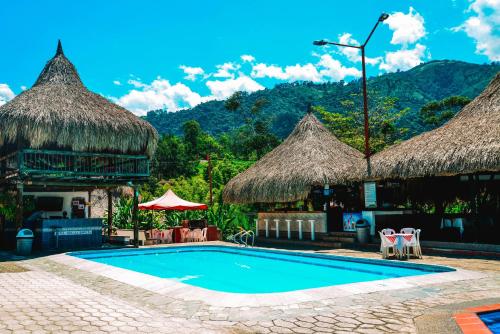 AmagáHotel Hacienda la Bonita的茅草小屋度假村的游泳池