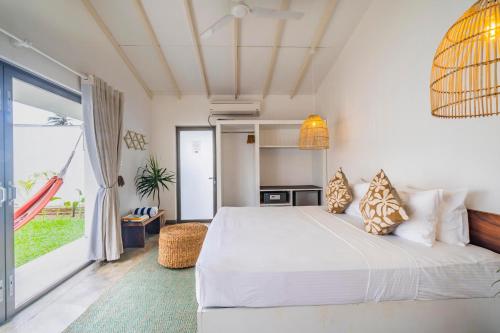 阿杭格默Global Surf Lodge Kabalana的一间卧室设有一张床和一个大窗户