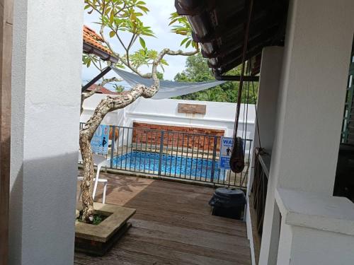 龙运Old Klang Road Homestay Dungun的甲板上的盆景树,带游泳池