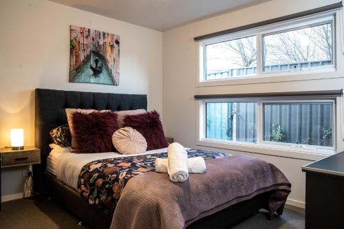 CanadianLake Esmond Place的一间卧室设有一张床和两个窗户。