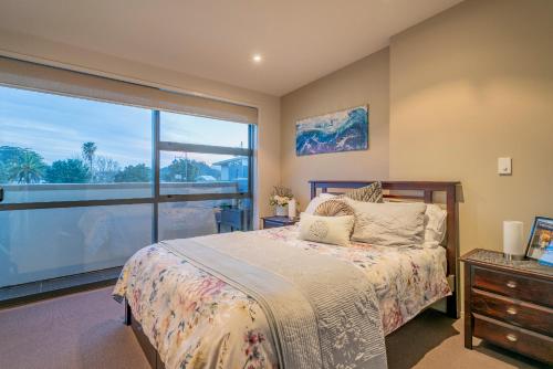 怀蒂昂格Waterways Serenity的一间卧室设有一张床和一个大窗户