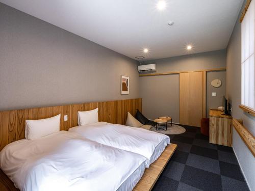 别府別府ホテル塒 Beppu Hotel Negura的卧室配有一张白色大床