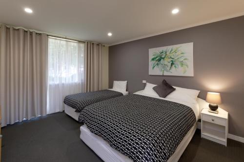 Keilor凯乐汽车旅馆的一间卧室设有两张床和窗户。