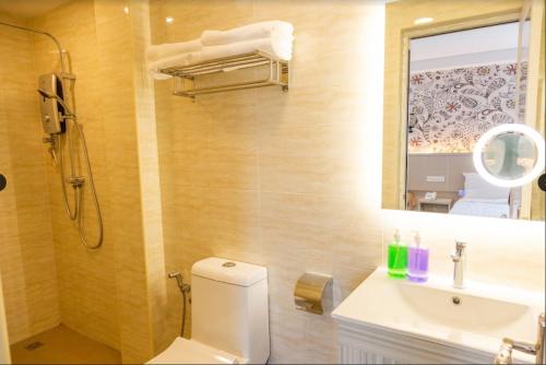 雪邦THE CROWN HOTEL @ KLIA的一间带卫生间、水槽和镜子的浴室