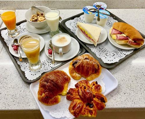 罗马擎天柱住宿加早餐旅馆的一张桌子,上面放着两个托盘,包括早餐食品和饮料