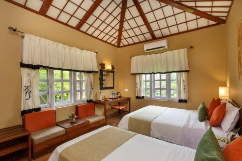 索拉哈绿色庄园丛林度假村的一间卧室设有两张床、一张桌子和窗户。