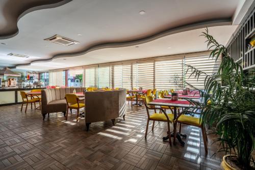 安塔利亚城市动态酒店的一间设有桌椅的餐厅,种植了植物