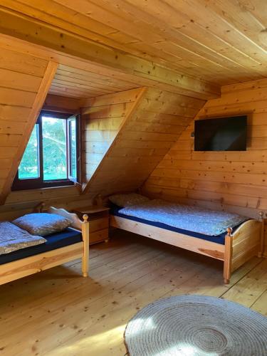 米沃姆温Domek nad jeziorem Winiec的小木屋内带两张床的房间