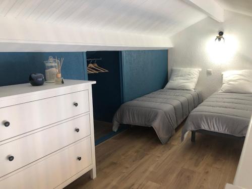 莱马特Maison au cœur de la La Palmyre的一间卧室配有两张单人床和一个梳妆台