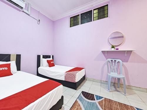 Kampung RajaOYO 90551 Zn Mix Homestay & Roomstay的一间卧室配有两张床、镜子和椅子