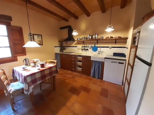 科尔努德利亚Mas del Salin的一间带桌子的厨房和一间带炉灶的厨房