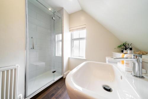布莱尔高里Robins Nest Cottage的带淋浴和盥洗盆的白色浴室
