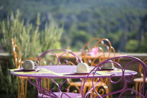 Mourèze莱斯豪特斯莫雷兹酒店的紫色桌子和椅子,上面有耳机